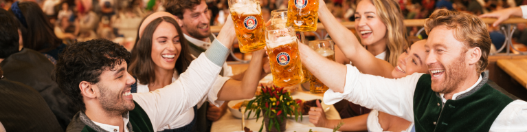 Besucher im Paulaner Festzelt stoßen an: Ein Prosit der Gemütlichkeit!
